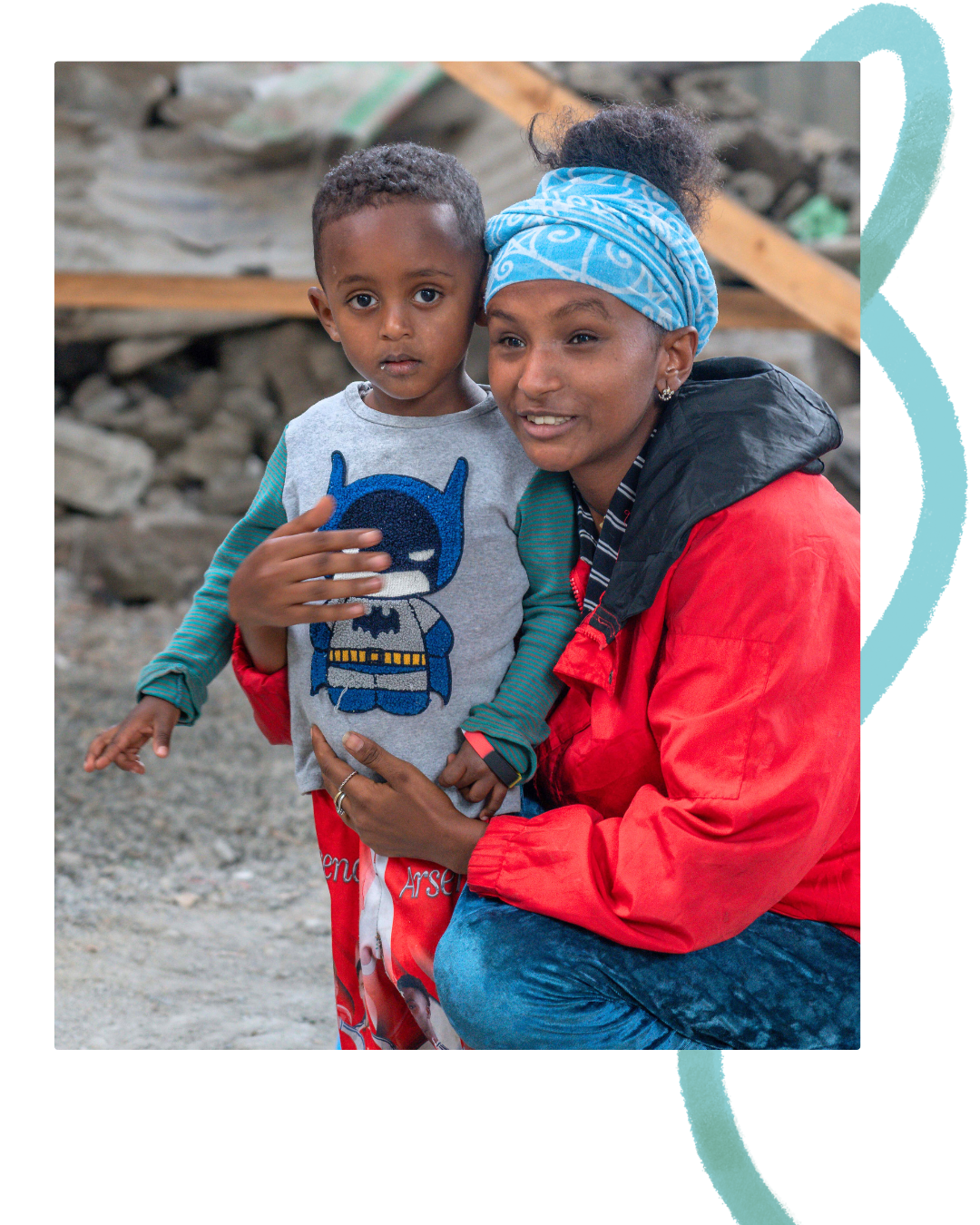 Ethiopian woman in a red jacket hugging her child, a 6 year old boy in a batman t-shirt. A thin blue thread starts behind the image.